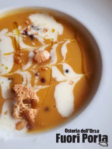 Crema variegata di zucca e taleggio fuso con pepe rosa e granella di amaretto