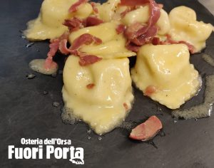 Tortelloni tartufati ripieni di robiola e ricotta saltati con crudo di Parma e burro